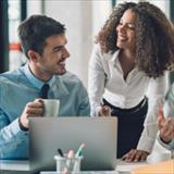 Man smiling at colleague and holding coffee cup