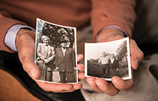 Dr. Ervin Staub holds a photo of his parents Rosza and Joszef Staub (left), and one of Maria Gogan (right) who helped his family in World War II.