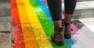 person wearing boots walking on a rainbow painted on the ground