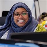 smiling woman wearing a headscarf and glasses