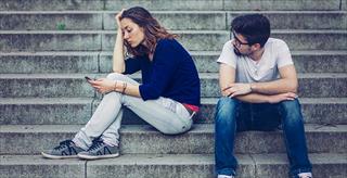 two teens sitting on concrete steps