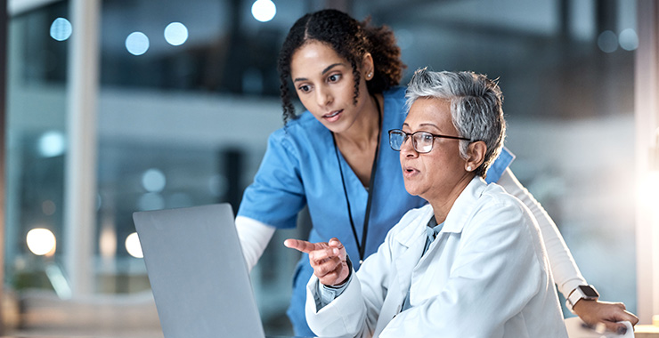 two professional women referring to something on a computer screen