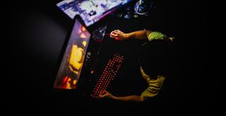 person playing video games using several monitors