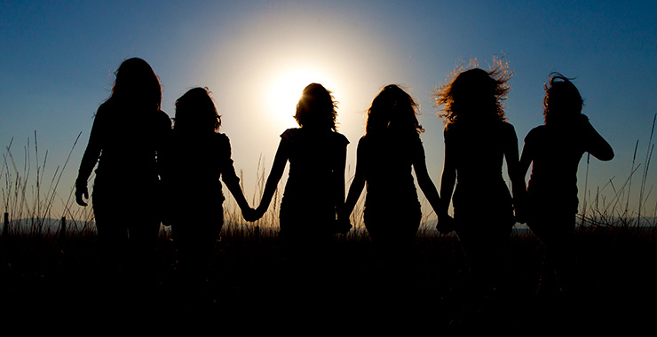 silhouette of a group of teen girls holding hands