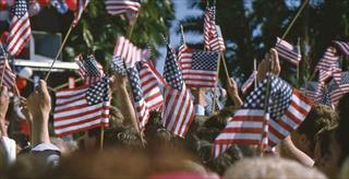 crowd of people holding american flags