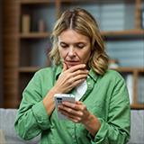  woman with concerned expression looking at smartphone