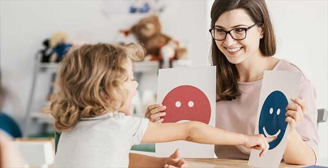 child pointing to happy or sad face