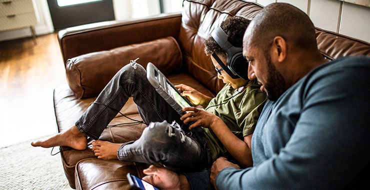 father and teen son looking at social media screens