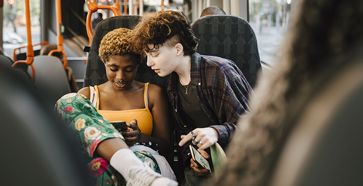 two teens looking at a smartphone