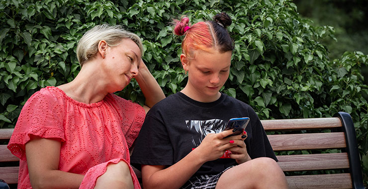 mother and daughter looking at smartphone screen