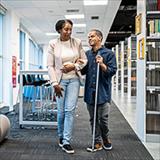 Teacher accompanies visually impaired student at university.