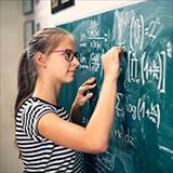 teen girl solving advanced math problems at blackboard