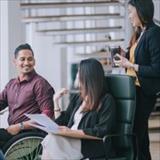 male worker in wheelchair talking with colleagues