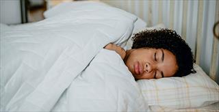 African American teenage girl asleep in bed.