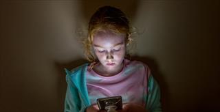 Tween girl staring at a smartphone