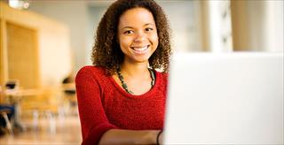 Young female college student using laptop.