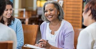 Older adult woman smiling with colleagues