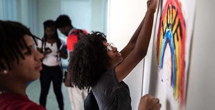 Woman hanging up LGBTQ pride art