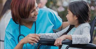 Nurse speaking with a child in a wheelchair