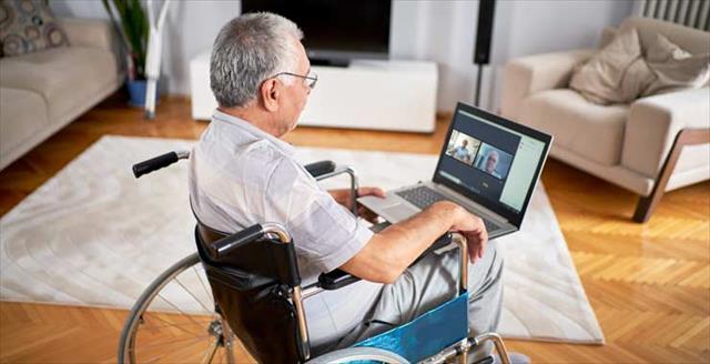 Senior citizen in a wheelchair on a laptop video call