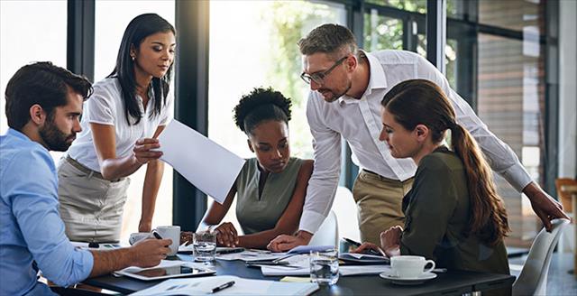 Diverse group of young professionals exchange ideas in the boardroom.