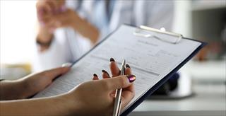 person completing a printed paper form