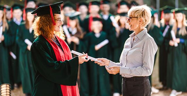 Student dons cap and gown at graduation