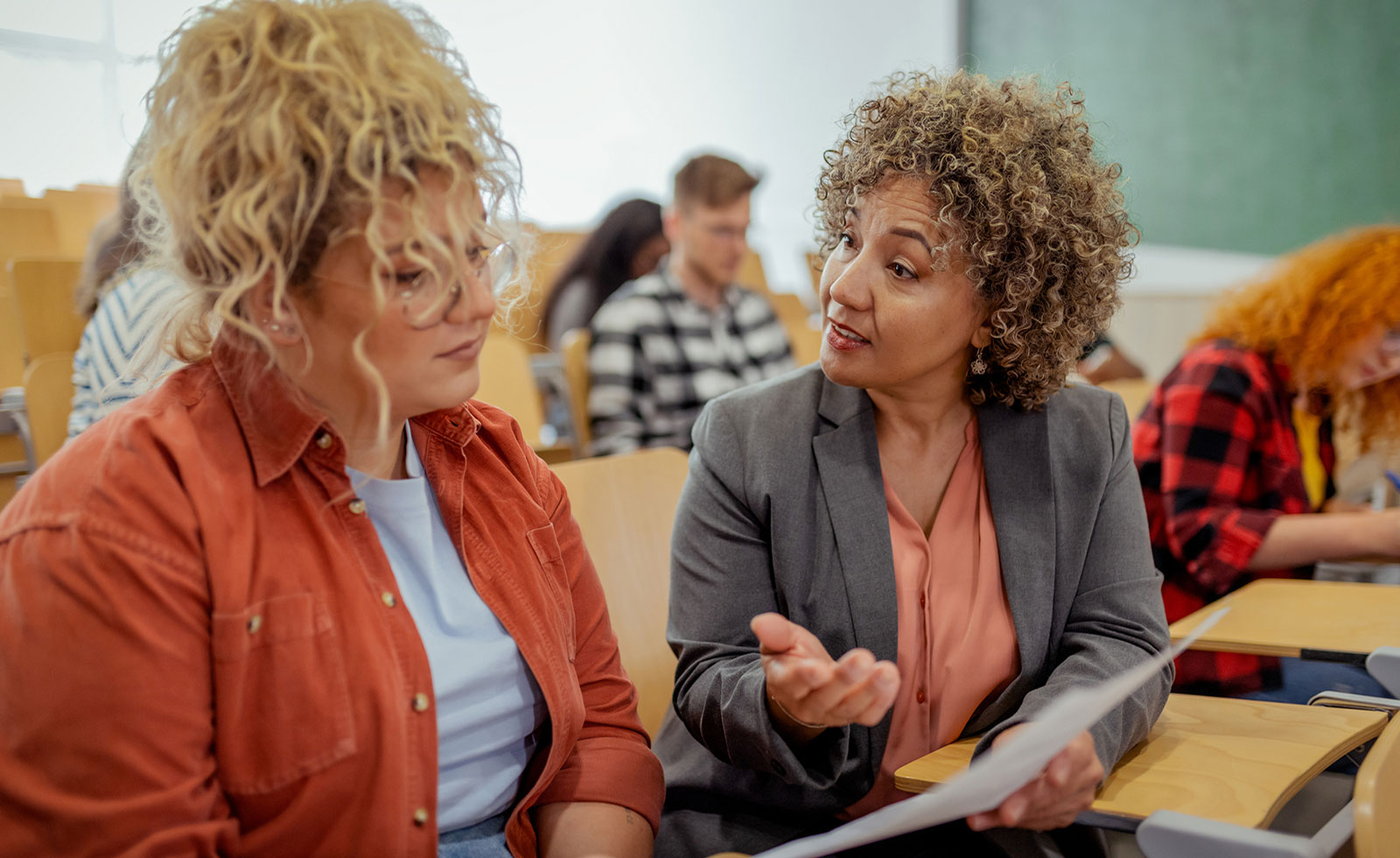 Female professor talking with young college student about her assessment.